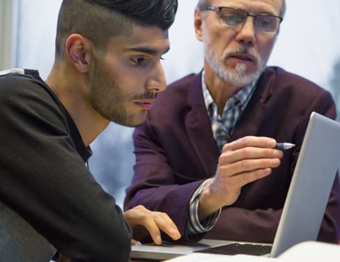 Add to Board  Professor and college student at laptop