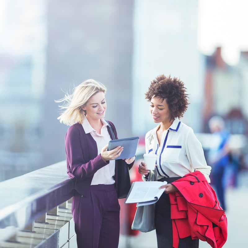 Two women walking together collaborating