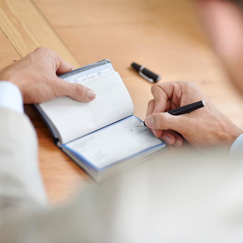 Cropped closeup shot of a businessman signing cheques