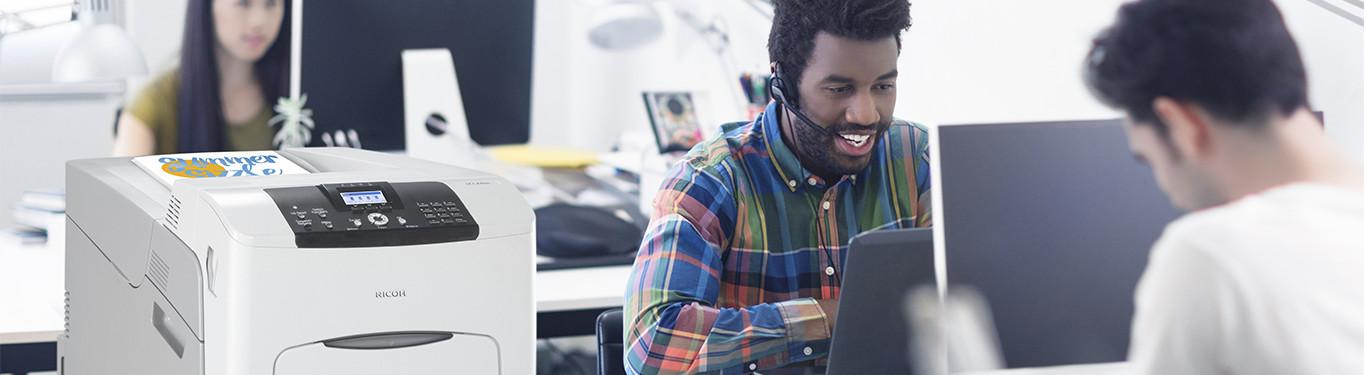 People working at computers with a printer in frame