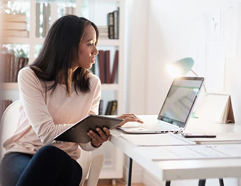 business woman on device and laptop