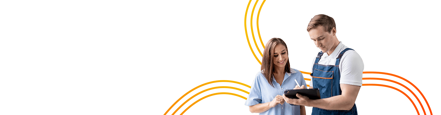 A woman smiling and pointing at a tablet that a young man is holding, both standing in an auto repair shop with a car and tools in the background, illustrating the importance of metrics in automotive maintenance.