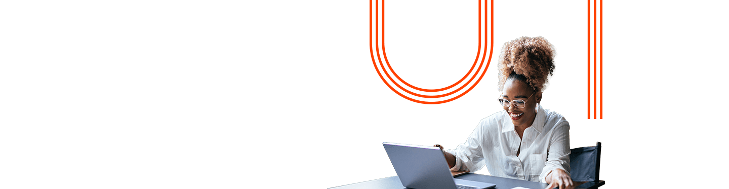 Professional reviewing documents while working on a laptop in an office setting, representing employee benefits, workplace support, and work-life balance.