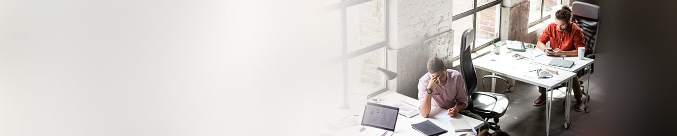 Two employees sitting at their desk seemingly distracted