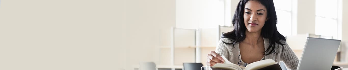 Woman at desk with books and laptop
